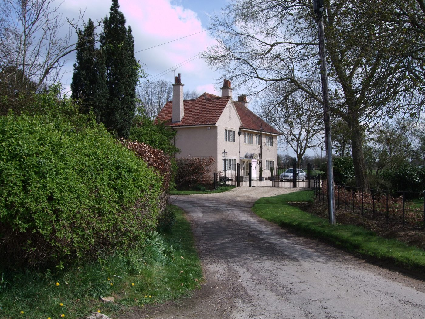 The Old Vicarage at Hankerton, a stone house behind a garden wall on the village lane